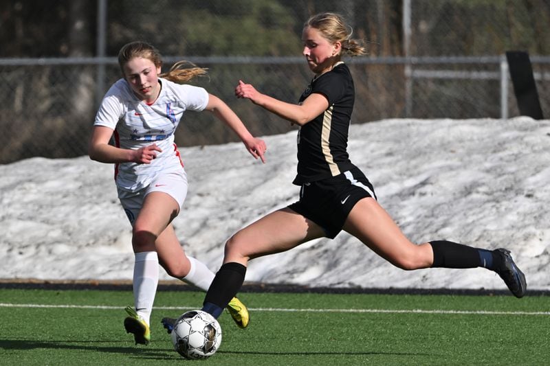 Ali Adkins of South, right, kicks the ball towards the goal as Beatrix Brogan of East High defends during the Wolverines' 7-0 home shutout against the Thunderbirds on Tuesday, May 7, 2024. (Bill Roth / ADN)