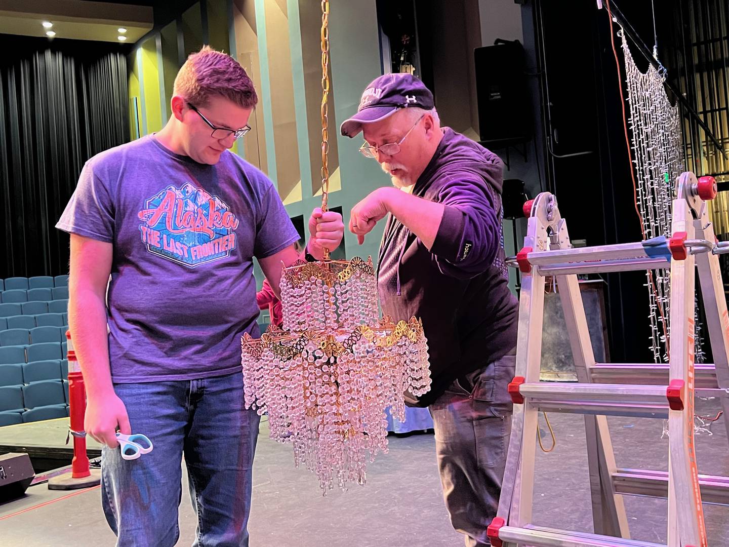 Technical director Wayne Mitchell, right, works with backstage crew member Steven Meyer on the Harmonia Gardens chandelier