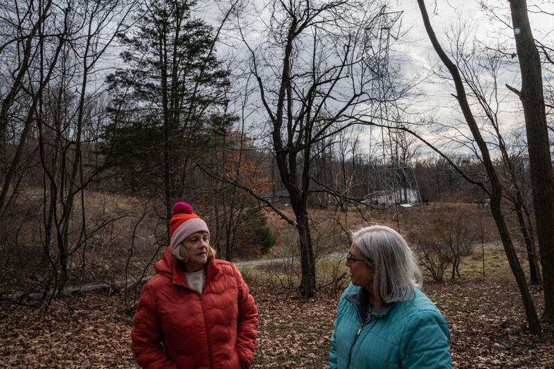 Pam Gearhart, left, speaks with activist Keryn Newman as she explains how close the transmission lines are to her Harpers Ferry property. (Salwan Georges/The Washington Post)