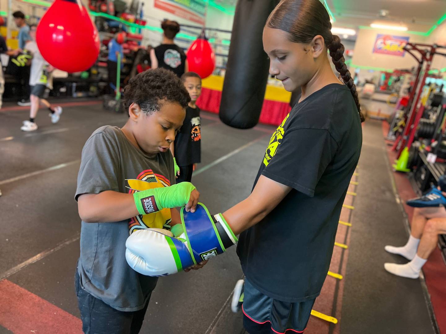 Maliyah Schmid gets a hand putting on her boxing glove