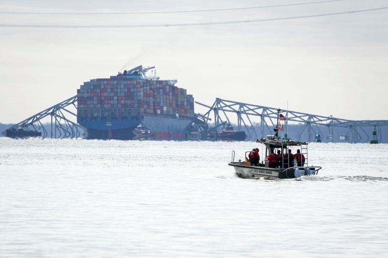 A U.S. Coast Guard boat heads toward the collapsed Francis Scott Key Bridge wreckage seen from Ft. McHenry, Md., on Tuesday, March 26, 2024. The bridge collapsed early Tuesday morning when a cargo ship collided with it. (Ulysses Muñoz/The Baltimore Banner via AP)