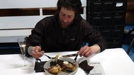 Iditarod musher Petit and his dogs chow down in Ruby after arriving first to the Yukon River town