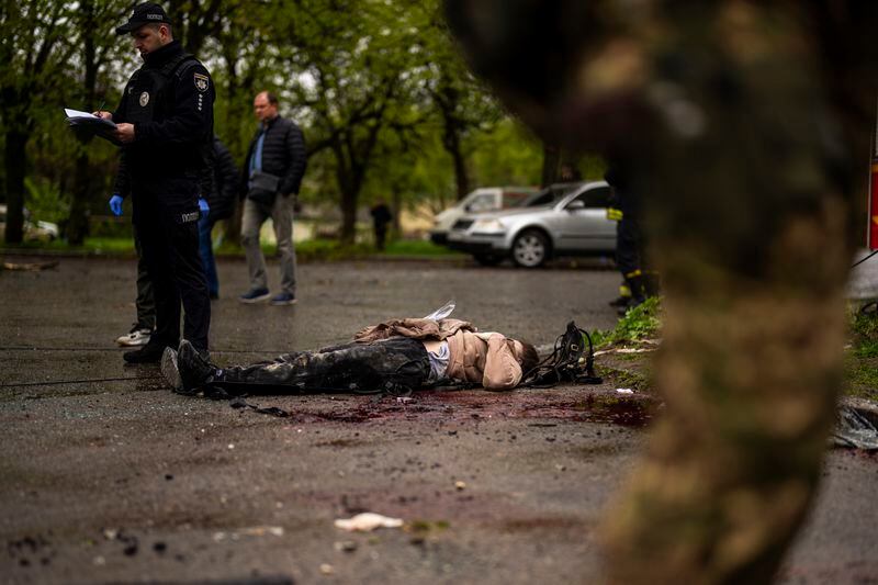 The body of a woman killed after a Russian bombardment, lies on the ground in Chernihiv, Ukraine, Wednesday, April 17, 2024. Three Russian missiles slammed into a downtown area of the northern Ukrainian city of Chernihiv on Wednesday, hitting an eight-floor apartment building and killing at least 17 people, authorities said. (AP Photo/Francisco Seco)