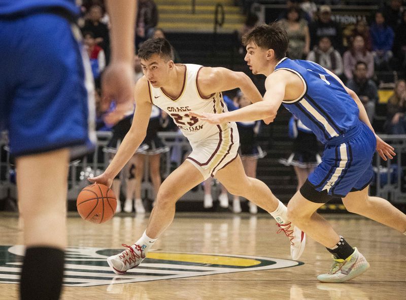 Grace Christian’s Kellen Jedlicka looks for a teammate as he moves past Nome defenders during the boys 3A championship game at the Alaska Airlines Center in Anchorage on Saturday, March 25, 2023. (Emily Mesner / ADN)