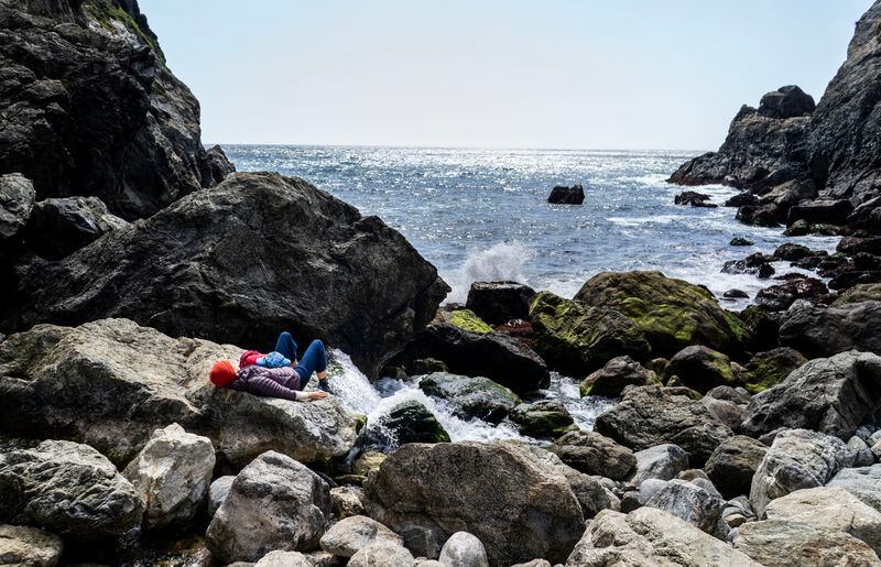 Since Highway 1 was closed by a landslide, Big Sur residents have been able to enjoy an empty Partington Cove Trail usually crowded with visitors. This sunbather enjoys the waves and wind April 6.