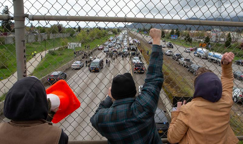 Anti-Israel Protesters cheer on others from the Harlow Road overpass as others block the south bound lane of Interstate 5 between Eugene, Ore., and Springfield below on Monday, April 15, 2024. (Chris Pietsch/The Register-Guard via AP)