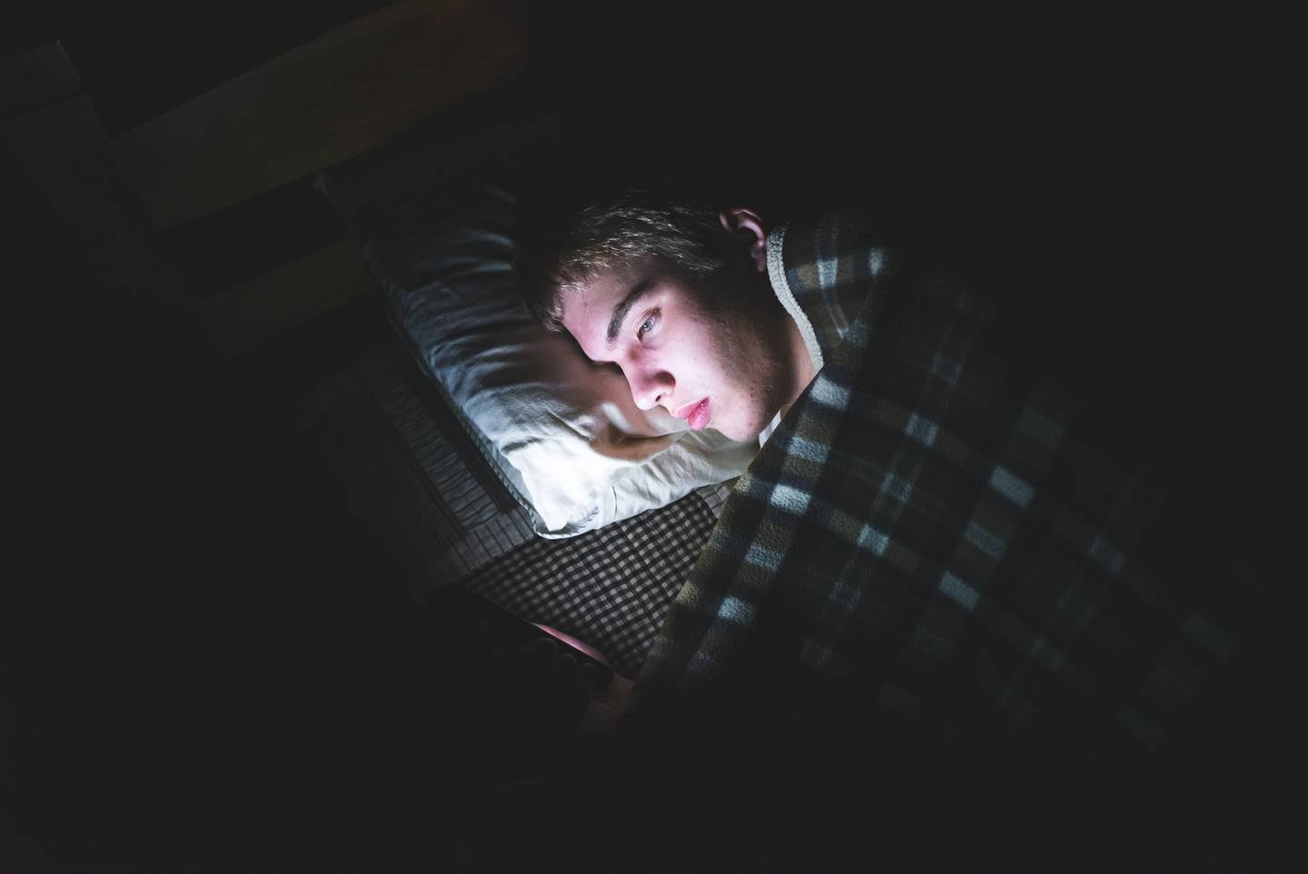 Teenager on his phone in the dark, sleeping, bed, smartphone, youth, stock, generic