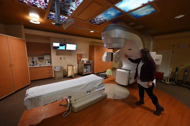 Elishaba Doerksen, who is undergoing 30 days of radiotherapy after being diagnosed with a brain tumor, points to the linear accelerator that delivers the radiation. (Bill Roth / ADN)