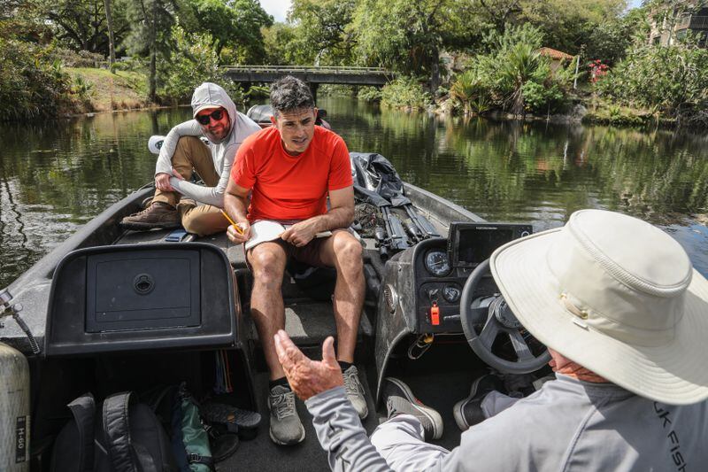 Michael, center, and Zack, left, talk to Captain Bud while traveling down a suburban canal in Fort Lauderdale. (Cindy Karp for The Washington Post)