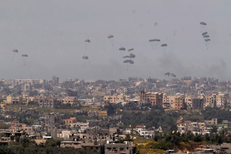 Parachutes drop supplies into the northern Gaza Strip, as seen from southern Israel, Wednesday, March 27, 2024. (AP Photo/Ohad Zwigenberg)
