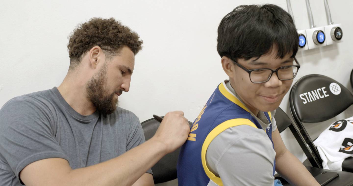 Klay Thompson signs one of his jerseys for Joseph Tagaban