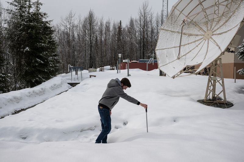 Meteorologist Matt Eovino measures the depth of the snow outside the National Weather Service’s Anchorage forecasting office on April 5, 2024. Accumulation, precipitation and snow depth measurements are made every six hours. (Marc Lester / ADN)