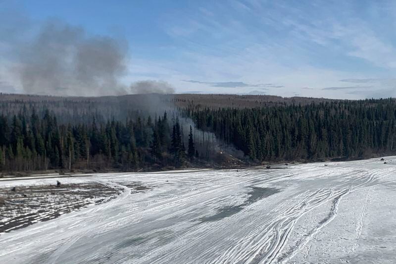 A fire burns after a Douglas C-54 Skymaster plane, a military version of the Douglas DC-4, crashed into the Tanana River outside Fairbanks, Alaska, Tuesday, April 23, 2024. (Alaska State Troopers via AP)