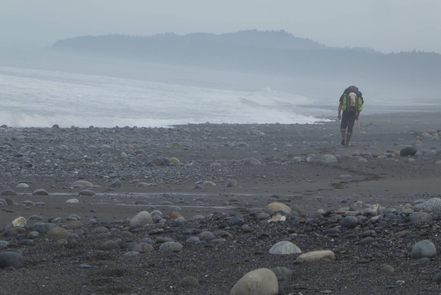 A scientist with a heavy backpack hikes the Lost Coast north of Lituya Bay