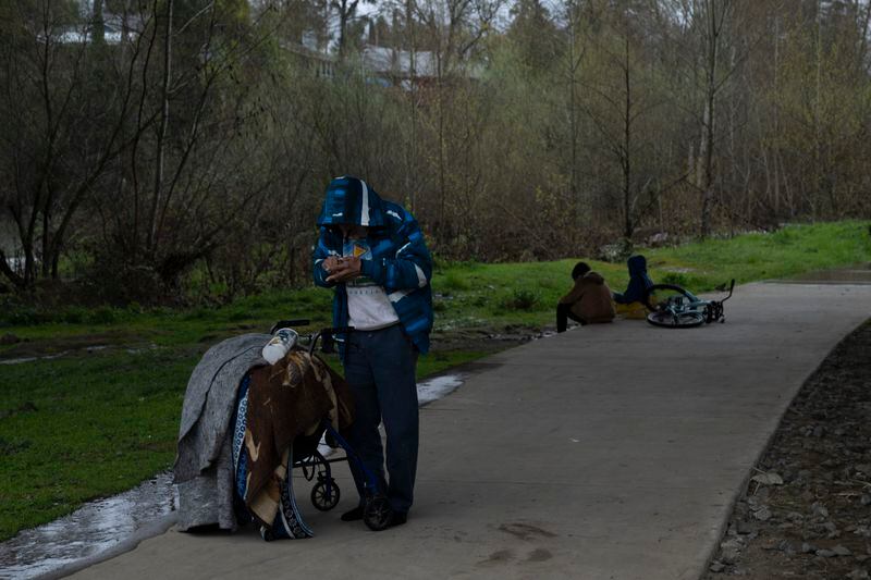 A homeless person tries to use a lighter to smoke drugs on Friday, March 22, 2024, in Grants Pass, Ore. (AP Photo/Jenny Kane)