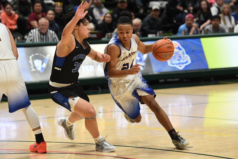 Hendrik Cumps, of Petersburg, defends as Latrell Lake, of Hooper Bay, drives for the basket in the 2A boys state basketball championship game at the Alaska Airlines Center in Anchorage on Saturday, March 16, 2024. Petersburg won the championship game 41-33. (Bob Hallinen Photo)