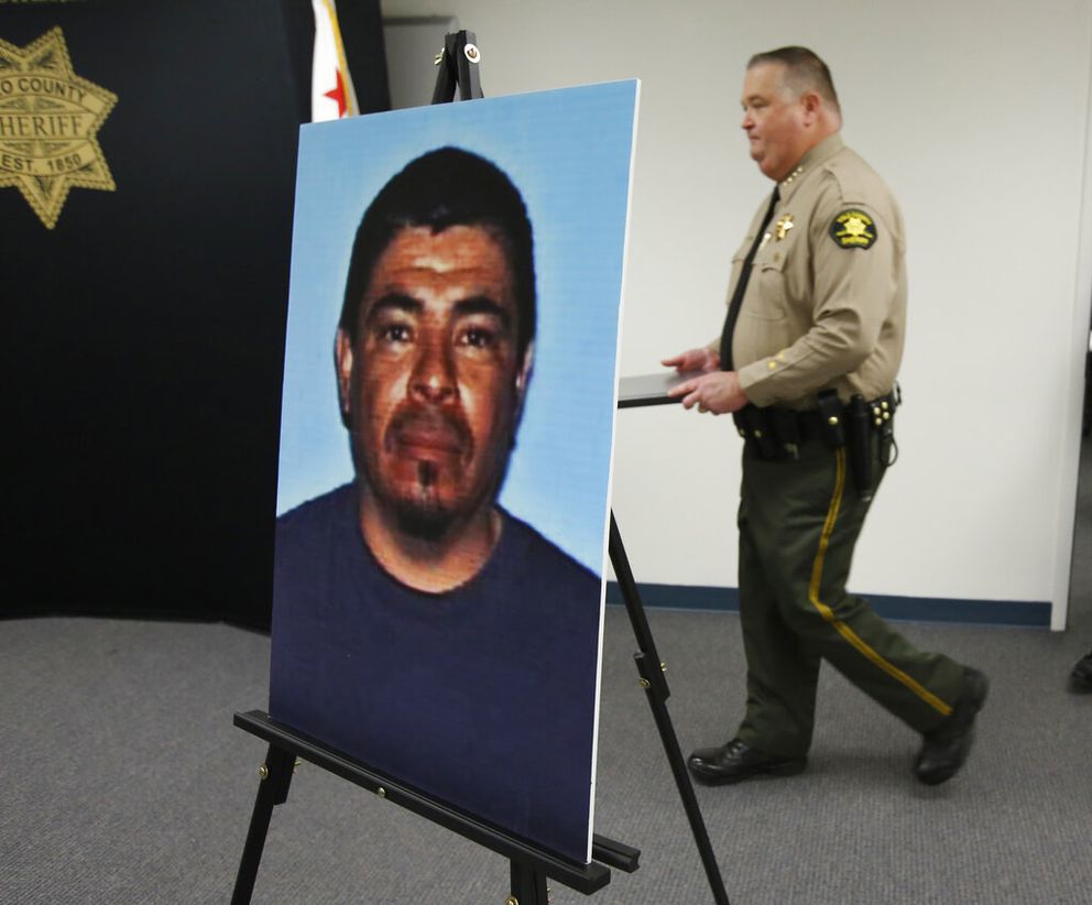 A photo of Paul Perez, who has been arrested in the deaths of his five children, is displayed as Yolo County Sheriff Tom Lopez, right, enters a news conference in Woodland, Calif., Monday, Jan. 27, 2020. Paul Perez, 57, has been arrested in the decades-old killings of five of his infant children, a case the sheriff said had haunted his agency for years, the Yolo County Sheriff's Office said Monday, Jan. 27, 2020. (AP Photo/Rich Pedroncelli)