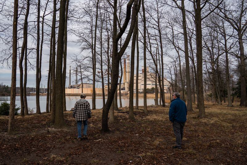 Darrell Abed, left, president of the board of directors for the Stoney Beach condo association, speaks with resident John Garofolo near the Herbert A. Wagner Generating Station. “We’re concerned about the air we’re breathing here,” Garofolo says. (Salwan Georges/The Washington Post)