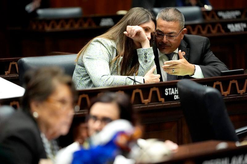 Arizona State Rep. Lupe Contreras, D, right, speaks with Stephanie Stahl Hamilton, D, on the House floor, Wednesday, April 17, 2024, at the Capitol in Phoenix. (AP Photo/Matt York)