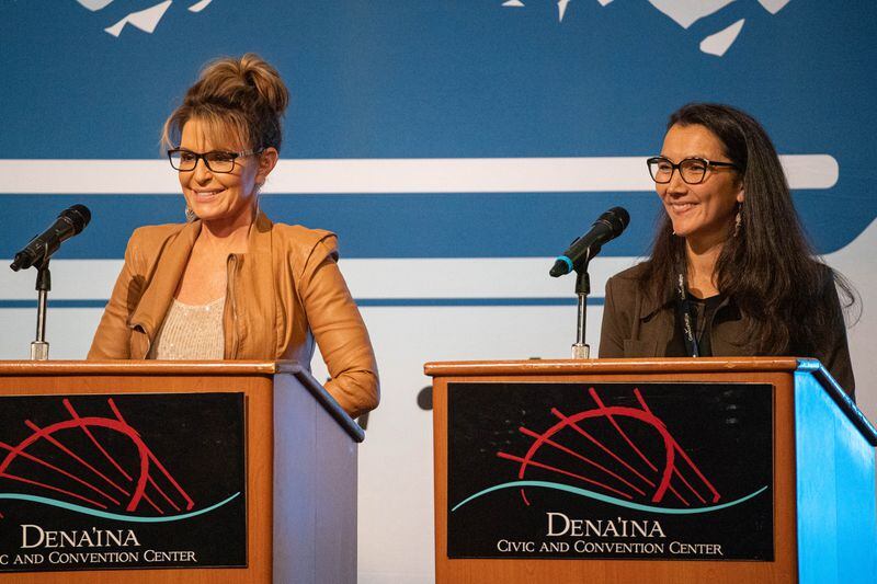 Sarah Palin, left, and Mary Peltola stand on stage before a U.S. House candidate forum at the Alaska Oil and Gas Association conference on Wednesday. (Loren Holmes / ADN)