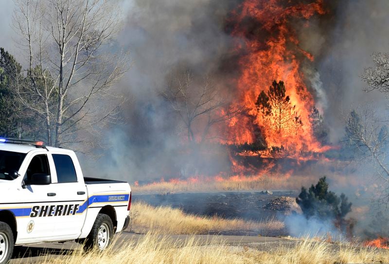 Fire continues to burn near a home at Middle Fork Road and Foothills Highway, north of Boulder, Colo., Thursday, Dec. 30, 2021. Crews battle multiple fires and wind damage around Boulder, Superior, and the county. (Cliff Grassmick/Daily Camera via AP)