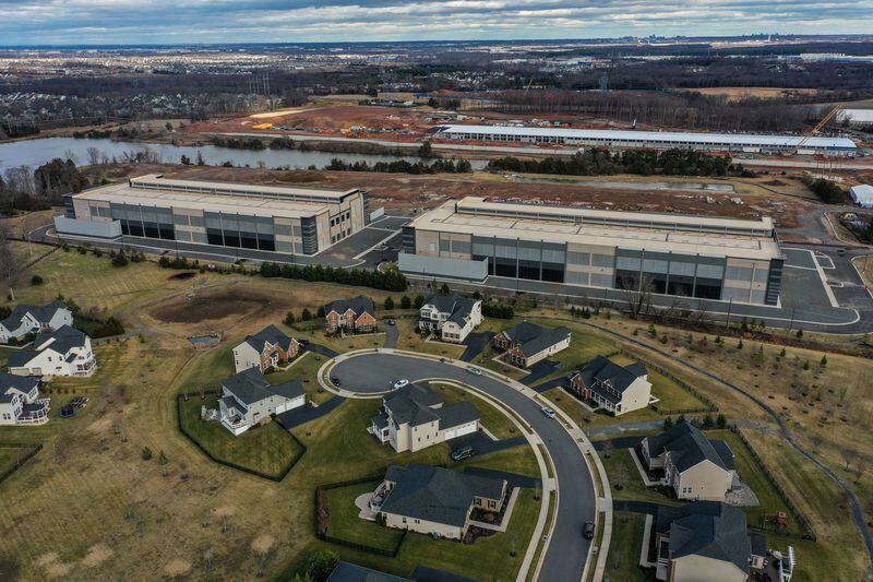An Amazon Web Services data center is located within about 50 feet of some residential homes in the Loudoun Meadows neighborhood in Ashburn, Va. A Microsoft data center is under construction at top right. (Jahi Chikwendiu/The Washington Post)