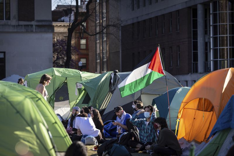People sit outside tents at the pro-Palestinian demonstration encampment at Columbia University in New York on Wednesday April 24, 2024. (AP Photo/Stefan Jeremiah)