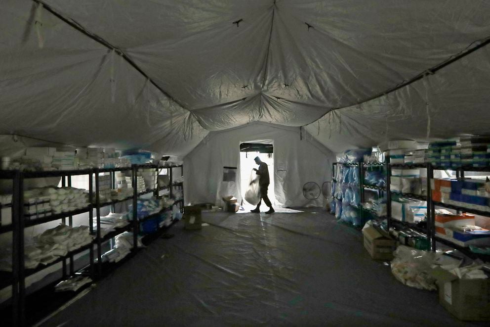 A U.S. Army soldier walks inside a mobile surgical unit being set up by soldiers from Fort Carson, Colo., and Joint Base Lewis-McChord as part of a field hospital inside CenturyLink Field Event Center, Tuesday, March 31, 2020, in Seattle. (AP Photo/Elaine Thompson)