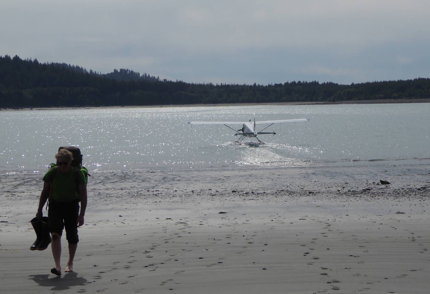 Dan Mann walks from a float plane in Anchorage Cove of Lituya Bay