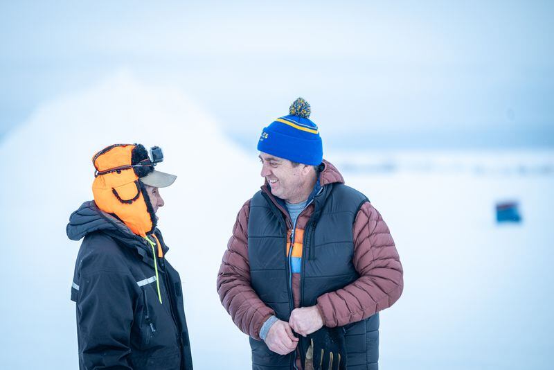 Gunnar Johnson (right) talks with Selawik volunteer Tillman Foster as the final teams depart the checkpoint. Photo by Whitney McLaren.