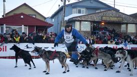 John Baker walks dogs under burled arch to win Iditarod 2011