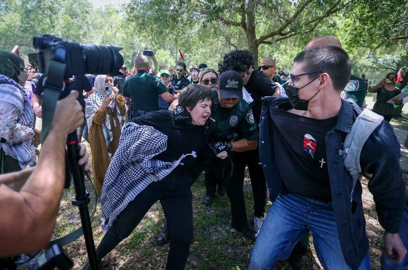 A pro Palestinian protester is grabbed by the University of South Florida's Police as they begin to clash on campus Monday, April 29, 2024 in Tampa. (Chris Urso/Tampa Bay Times via AP)