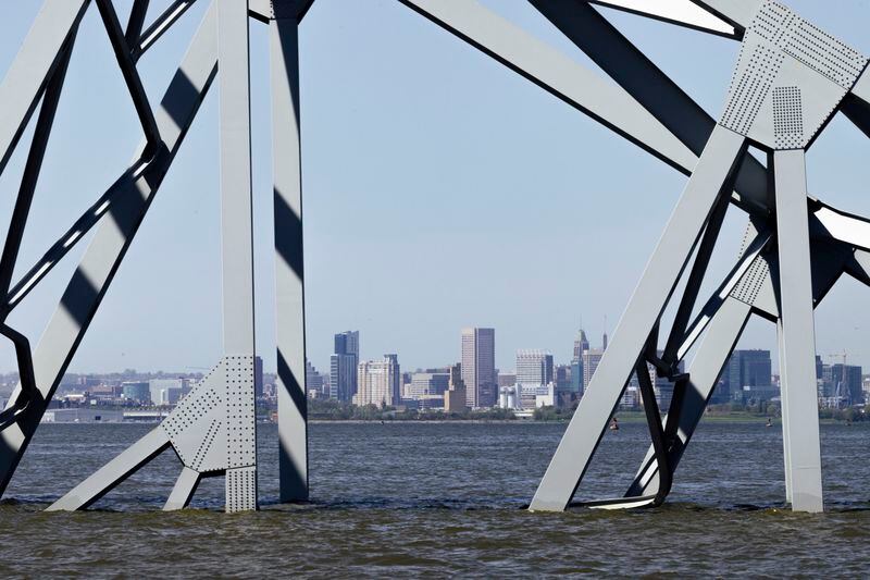 Downtown Baltimore is seen Tuesday through partially submerged trusses of the collapsed Key Bridge. (Wesley Lapointe for The Washington Post)