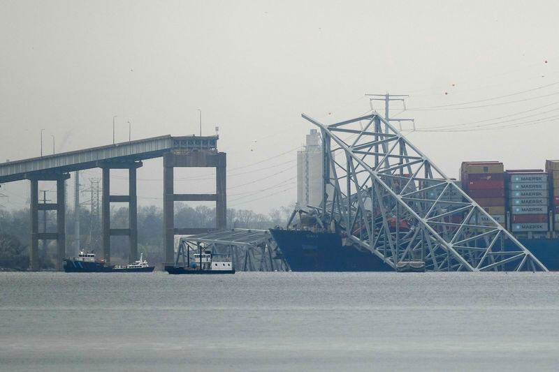A container ship rests against wreckage of the Francis Scott Key Bridge on Wednesday, March 27, 2024, in Baltimore, Md. Recovery efforts resumed Wednesday for the construction workers who are presumed dead after the cargo ship hit a pillar of the bridge, causing the structure to collapse. (AP Photo/Matt Rourke)