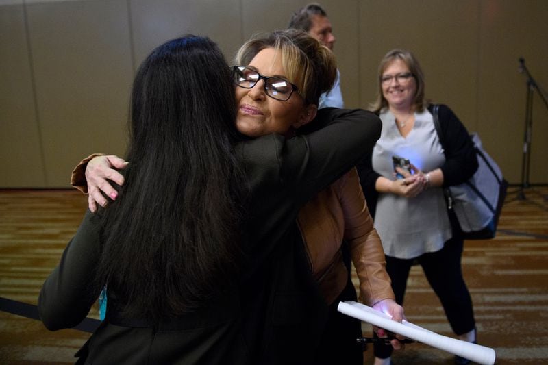 Sarah Palin  and Mary Peltola hug before a candidate forum on Wednesday at the Alaska Oil and Gas Association convention in Anchorage. (Marc Lester / ADN)