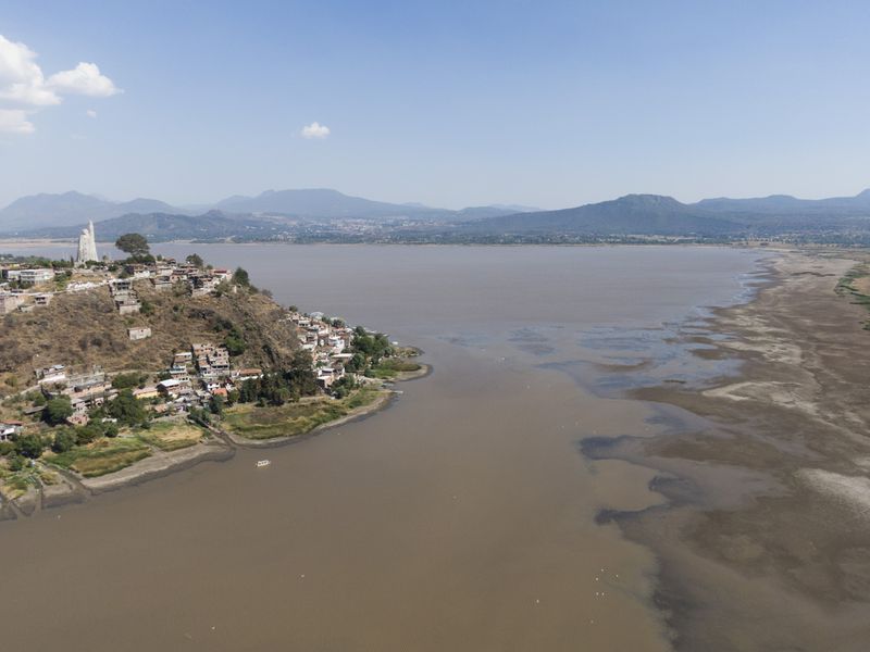 Janitzio Island stands in Lake Patzcuaro, which has low water levels during a drought in Mexico, Thursday, April 18, 2024. Farmers are starting to pasture livestock and plant crops on the lake bed. (AP Photo/Armando Solis)