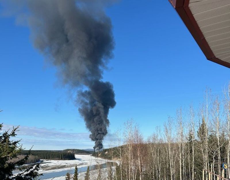 A smoke column rises from a Douglas DC-4 that crashed Tuesday about 7 miles south of the Fairbanks International Airport on the Tanana River. Alaska State Troopers say two people were in the plane when it crashed and no survivors have been found. (Photo provided by Gary Contento)