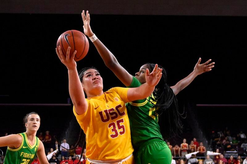 Southern California forward Alissa Pili, center, shoots as Oregon forward Ruthy Hebard, right, defends and guard Sabrina Ionescu watches during the second half of an NCAA college basketball game Sunday, Feb. 16, 2020, in Los Angeles. Oregon won 93-67. (AP Photo/Mark J. Terrill)