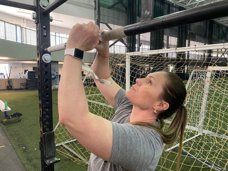 Joanna Livaudais tapes the pull-up bar at the Ben Eielson Air Force Base in preparation for a CrossFit class she teaches. Her three sons will be affected by the closure of the base’s junior and senior high school at the end of the year. (Photo by Claire Stremple/Alaska Beacon)
