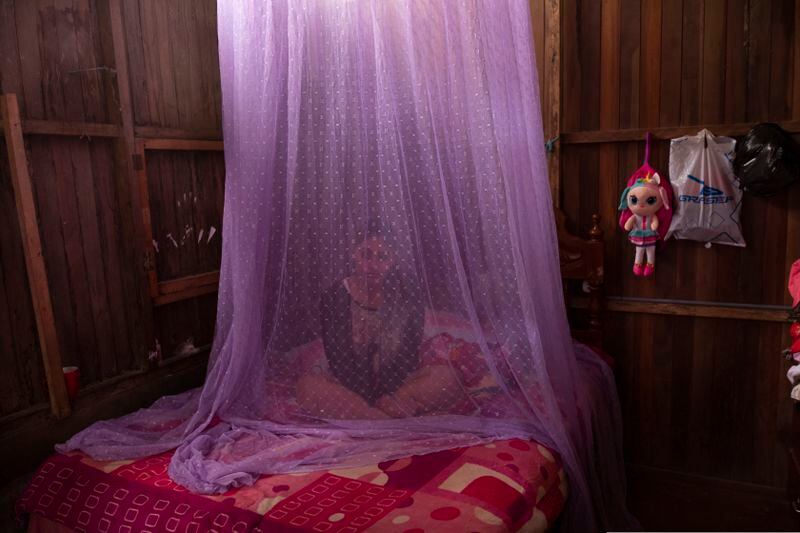 A girl recovering from dengue sits on her bed protected by mosquito netting in Peru. (AP Photo/Rodrigo Abd)