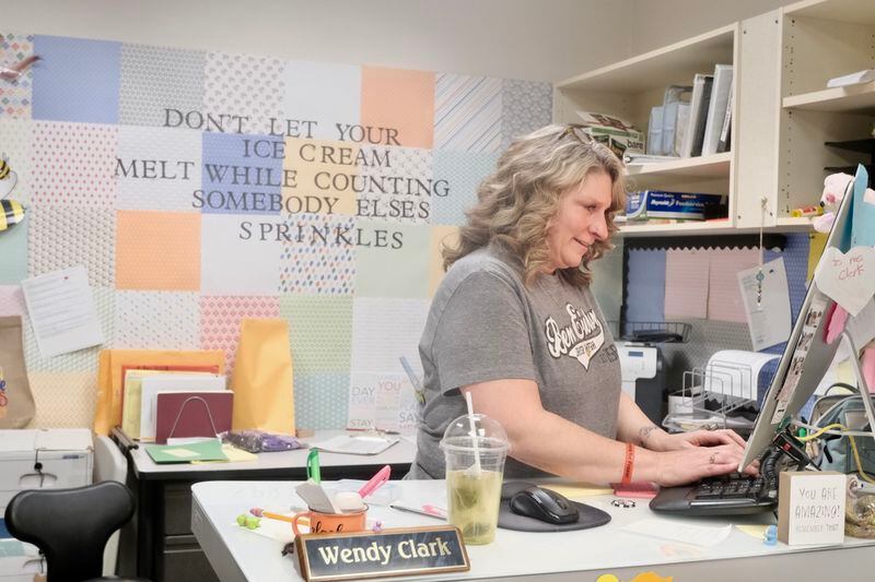 Wendy Clark keeps an eye on students coming in to the front desk as she manages work on her computer on April 22, 2024. She said she is “salty” about the closure of Ben Eielson at the end of the school year. (Photo by Claire Stremple/Alaska Beacon)