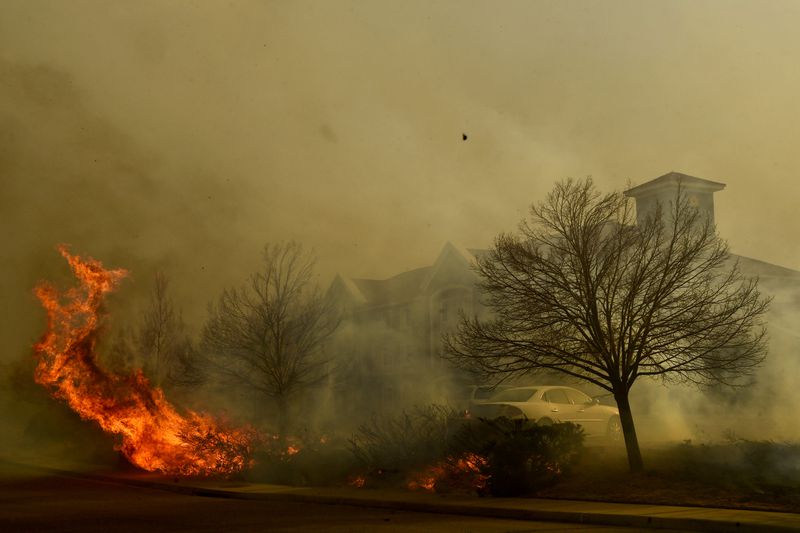 A wildfire burns near homes, Thursday, Dec. 30, 2021, in Superior, Colo. An estimated 580 homes, a hotel and a shopping center have burned and tens of thousands of people were evacuated in wind-fueled wildfires outside Denver, officials said Thursday evening. (Helen H. Richardson/The Denver Post via AP)