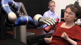 Paralyzed woman uses thoughts to control robot arm